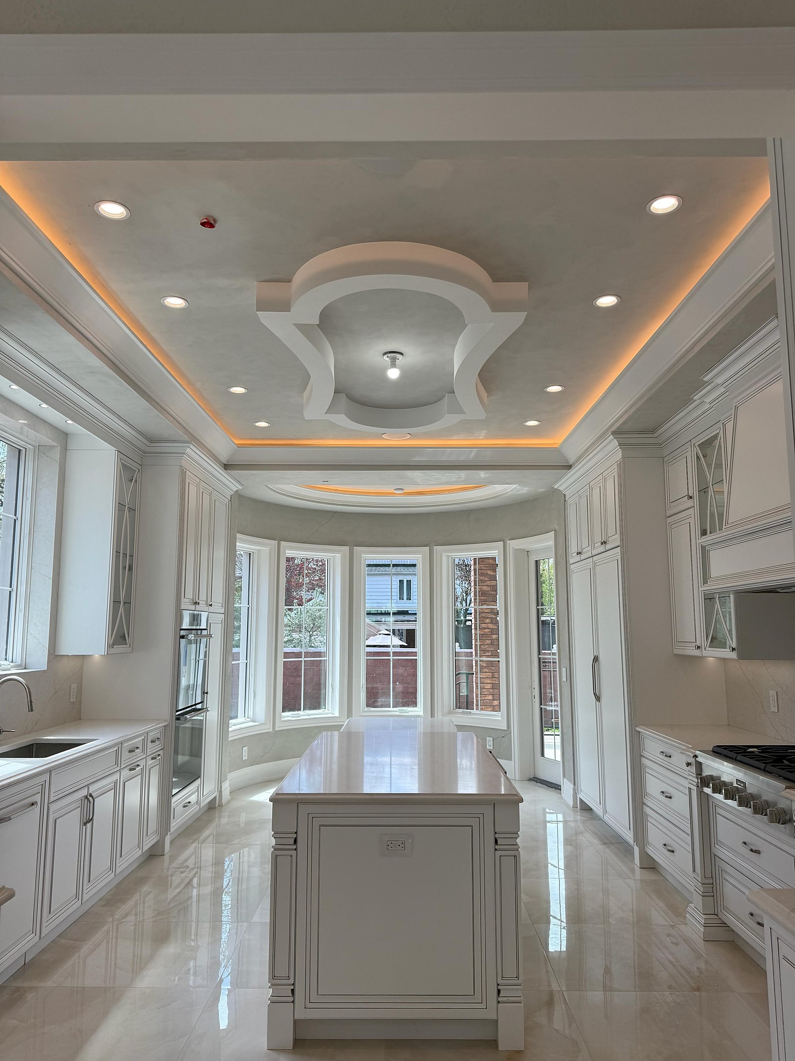 Great Neck estate kitchen with a coffered decorative plaster ceiling, LED cove, and bay window — MarkOn® Walls