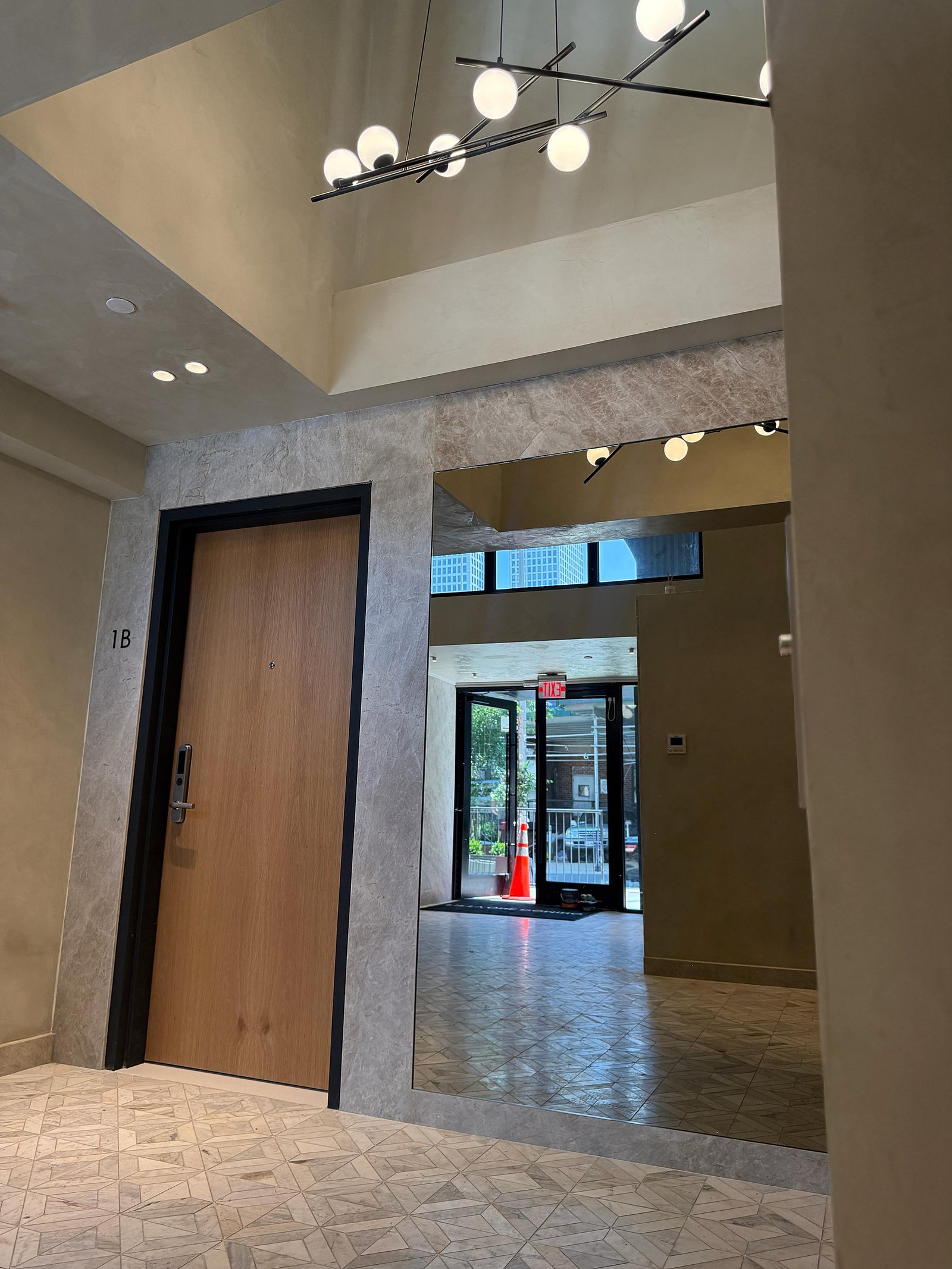 Lobby vestibule with limewashed walls, framed marble portal and alabaster fixture over a marble-mosaic floor — MarkOn® Walls